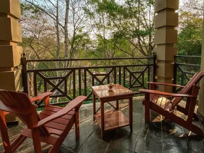 a patio with two chairs and a table on a balcony at Fairview Hotels,Spa & Golf Resort in Tzaneen
