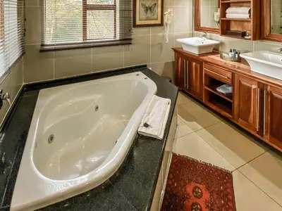 a large bathroom with a tub and a sink at Fairview Hotels,Spa & Golf Resort in Tzaneen