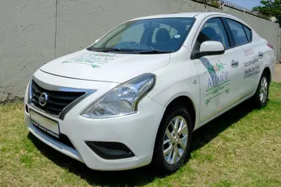 a white car parked on the grass in a yard at Alimop Bed and Breakfast in Midrand