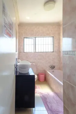 a bathroom with a tub and a toilet and a sink at Alimop Bed and Breakfast in Midrand