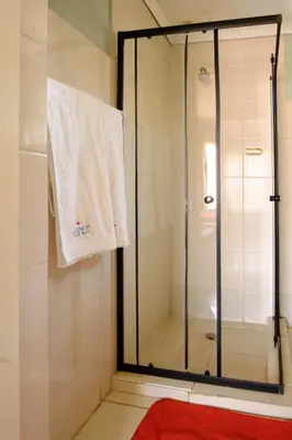 a shower with a glass door and a towel at Alimop Bed and Breakfast in Midrand
