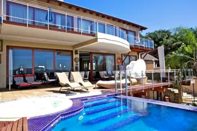 a house with a swimming pool in front of a house at Kosmos Manor Guest House in Hartbeespoort