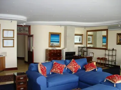 a living room with a blue couch with red pillows at Kosmos Manor Guest House in Hartbeespoort