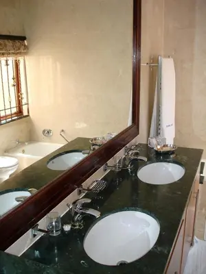a bathroom with two sinks and a large mirror at Kosmos Manor Guest House in Hartbeespoort