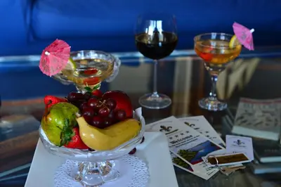 a bowl of fruit on a table with glasses of wine at Kosmos Manor Guest House in Hartbeespoort