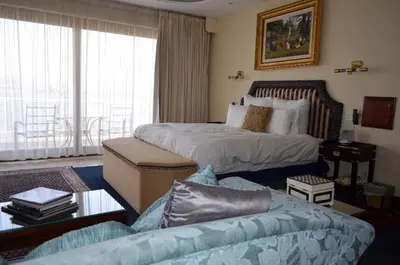 a hotel room with two beds and a couch at Kosmos Manor Guest House in Hartbeespoort