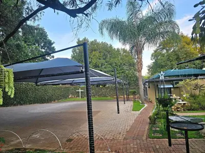 a patio with an umbrella and a table and chairs at Apricity Inn in Louis Trichardt