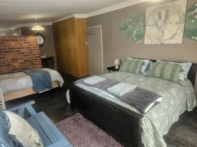 a bedroom with a large bed and a bedskirts at Apricity Inn in Louis Trichardt