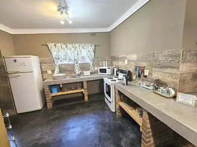 a kitchen with a white refrigerator and a counter top at Apricity Inn in Louis Trichardt