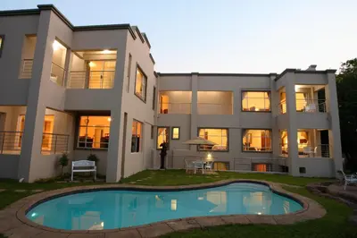 an exterior view of a large house with a swimming pool at Global Village Guest House in Nelspruit