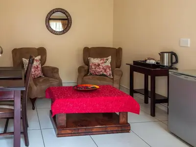 a living room with a red table and chairs at Global Village Guest House in Nelspruit