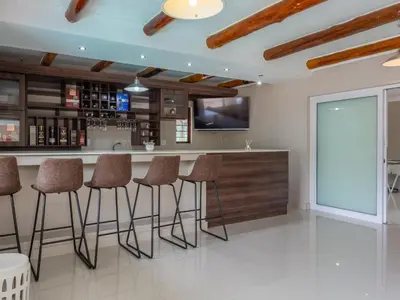 a kitchen with a bar with stools at Global Village Guest House in Nelspruit
