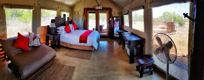 a bedroom with a bed and a couch in a room at OuKlip Game Lodge in Klipdrift