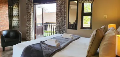 a bedroom with a large bed with towels on it at Accolades Boutique Venue in Midrand