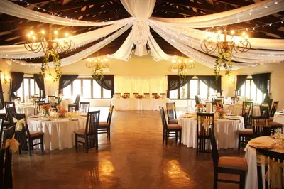 a banquet hall with tables and chairs and chandeliers at Accolades Boutique Venue in Midrand