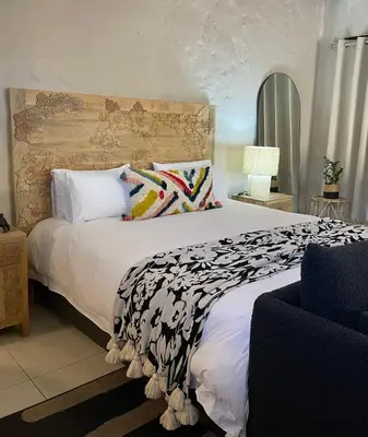 a bedroom with a large bed with a black and white comforter at Bly B&B in Pretoria