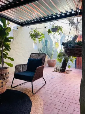 a chair sitting on a patio with potted plants at Bly B&B in Pretoria