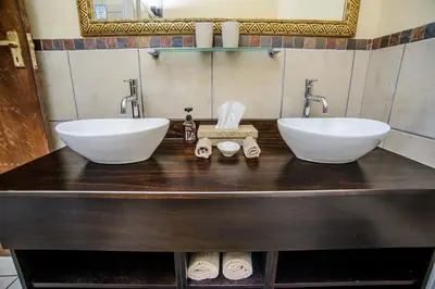 a bathroom with two white sinks on a counter at Abangane Guest Lodge in Hazyview