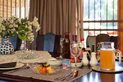 a dining room table with a table cloth with drinks and a table at Aberfeldy Bed & Breakfast in Midrand