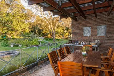 an outdoor patio with a wooden table and chairs at Aberfeldy Bed & Breakfast in Midrand