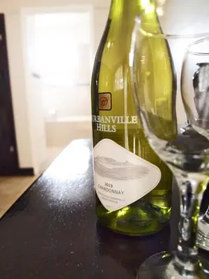 a bottle of wine sitting next to a wine glass at Travel Lodge Sabie in Sabie