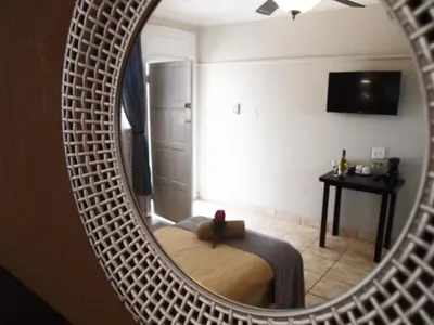 a mirror reflecting a bedroom with a bed in a room at Travel Lodge Sabie in Sabie