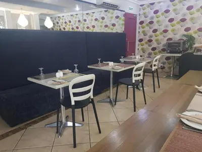 a dining room with tables and chairs in a restaurant at Midrand Conference Centre in Midrand