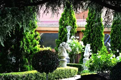 a garden with two statues in front of a building at Midrand Conference Centre in Midrand
