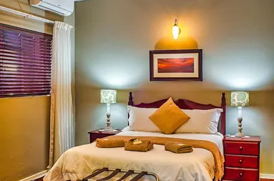 a bedroom with a bed with two towels on it at Amper Bo Guest House in Pretoria