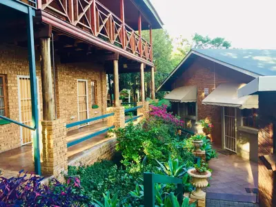 a building with a courtyard with flowers and plants at Amper Bo Guest House in Pretoria