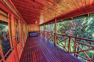 a balcony of a cabin with a view of trees at Amper Bo Guest House in Pretoria