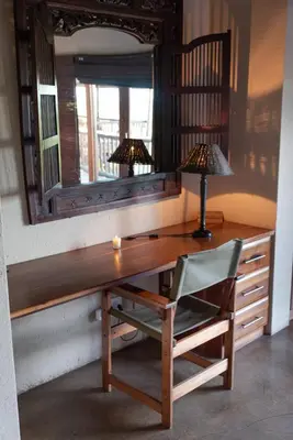 a desk with a mirror and a chair and a lamp at Parsons House in Hoedspruit