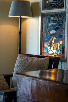 a table and a lamp in a room with a chair at Parsons House in Hoedspruit