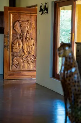 a toy dog standing in front of a wooden door at Parsons House in Hoedspruit