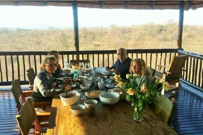 a group of people sitting around a wooden table at Parsons House in Hoedspruit