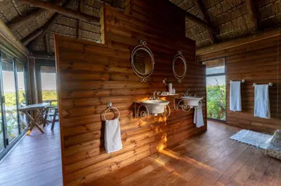 a bathroom with two sinks in a wooden wall at Parsons House in Hoedspruit