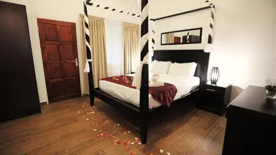 a bedroom with a canopy bed and a wooden floor at African Rest Lodge in Barberton