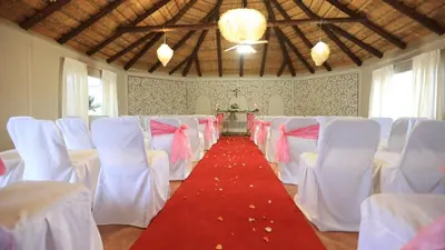 a room with white chairs and a red carpet at African Rest Lodge in Barberton