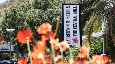 a sign in front of a building with flowers at African Rest Lodge in Barberton