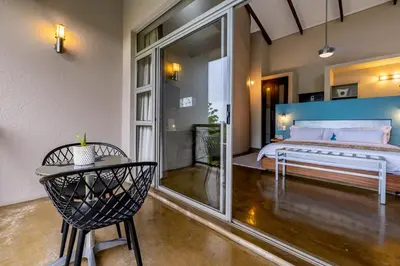 a bedroom with a bed and a table and a chair at Francolin Lodge in Nelspruit