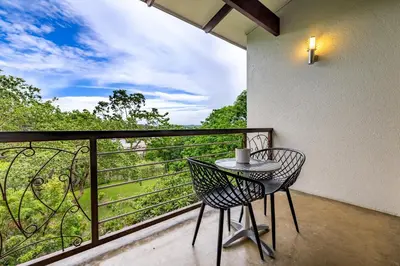 a table and chairs on a balcony with a view at Francolin Lodge in Nelspruit
