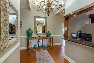 a hallway with a mirror and a counter with a mirror at Francolin Lodge in Nelspruit