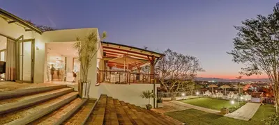 a house with a view of a backyard at Francolin Lodge in Nelspruit