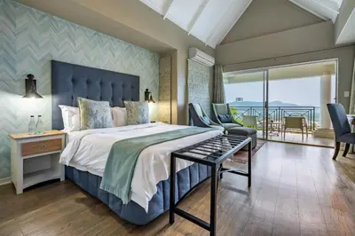 a bedroom with a large bed and a balcony at Loerie's Call Guesthouse in Nelspruit