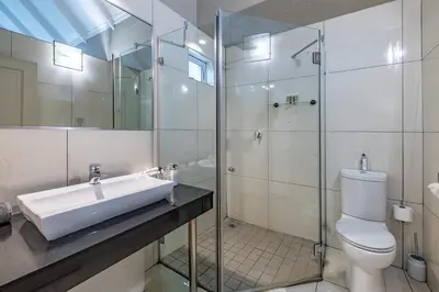 a bathroom with a sink and a toilet and a shower at Loerie's Call Guesthouse in Nelspruit