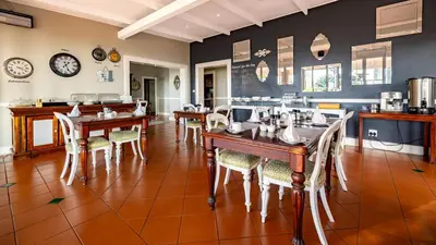 a dining room with wooden tables and chairs at Loerie's Call Guesthouse in Nelspruit