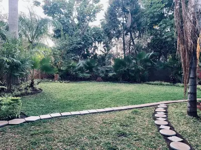 a garden with a rock path in the grass at Xisaka Guest House in Giyani