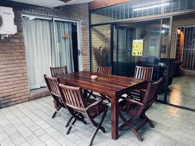 a wooden table and chairs on a patio at Xisaka Guest House in Giyani