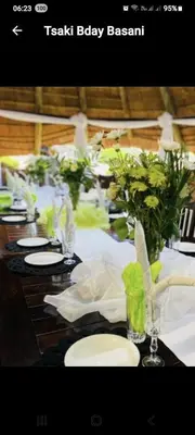 a long table with white plates and flowers on it at Xisaka Guest House in Giyani