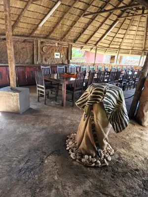 a dining room with a table and chairs in a building at Xisaka Guest House in Giyani